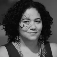 Foto preta e branca de Deyse, uma mulher de pele clara e cabelos cacheados na altura dos ombros