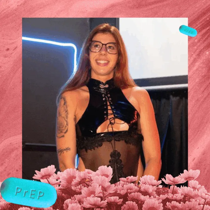 A imagem mostra uma mulher sorridente, de cabelos longos e ruivos, usando óculos e um vestido preto justo com detalhes em renda. Ela tem uma tatuagem no braço e está em frente a um fundo escuro com luz azul em neon. A foto é emoldurada por um fundo cor-de-rosa, com flores na parte inferior e comprimidos azuis com a inscrição “PrEP” nos cantos.