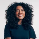 Mulher negra não retinta de cabelos longos e cacheados