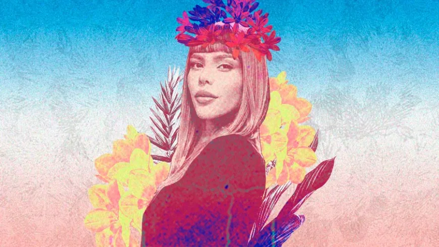 Ilustração em tons de rosa, azul e amarelo de Patty Michelletti, que tem cabelos lisos e usa franja. Ela está com uma coroa de flores coloridas, cercada por flores e folhas, em fundo degradê suave, representando a força e a delicadeza das mulheres trans.