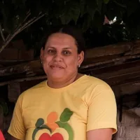 Tamires Costa Silva é uma mulher negra de cabelos escuros. Ela está de cabelo preso e usa uma blusa amarela.