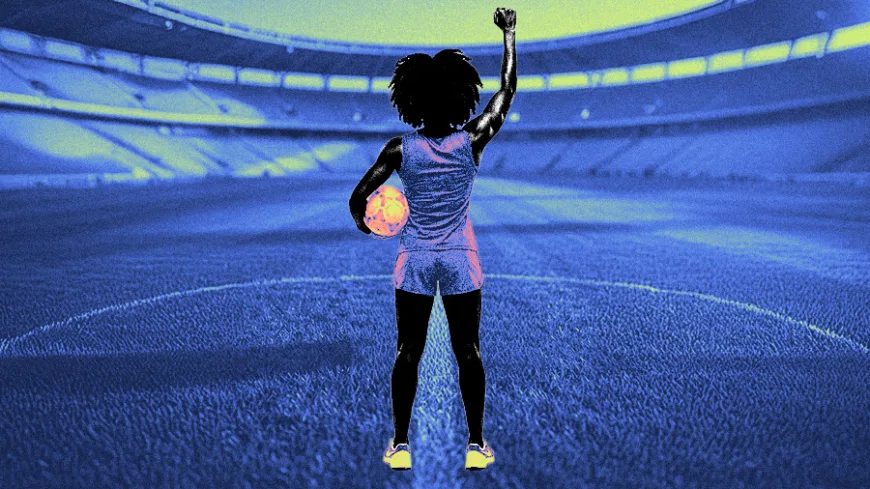 A imagem mostra a silhueta de uma mulher vista de costas, posicionada no centro de um estádio de futebol vazio. Ela tem cabelo crespo volumoso e veste roupa esportiva — regata e short. Com uma das mãos, segura uma bola de futebol junto ao corpo; com a outra, levanta o punho fechado para o alto, em gesto de força ou protesto. O campo e as arquibancadas ao redor aparecem em tons de azul, criando um ambiente amplo e imersivo. A figura da mulher e a bola recebem cores mais quentes, como rosa e laranja, destacando-se do fundo. A composição sugere presença, resistência e ocupação de um espaço historicamente masculino.
