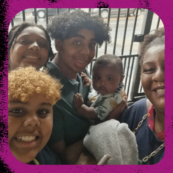 Laís é negra, está com os cabelos presos, e acompanhada dos quatros filhos: três adolescentes e um bebê.