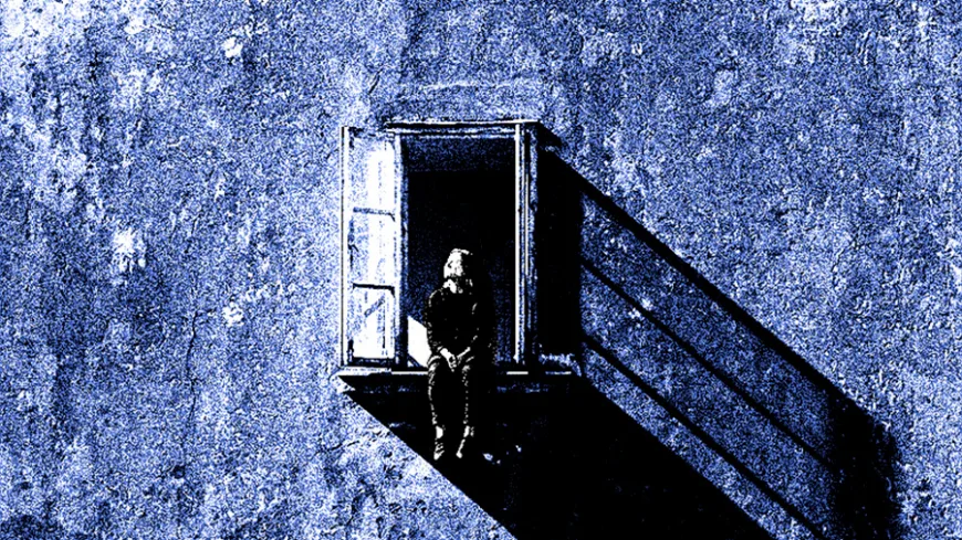 Ilustração em tons de azul e preto mostra uma pessoa sozinha, sentada no parapeito de uma janela aberta em uma grande parede de textura áspera. A luz que entra pela abertura projeta uma longa sombra diagonal sobre a fachada. A composição transmite sensação de isolamento, silêncio e solidão.